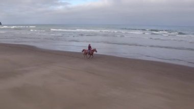 Kumsalda ata binen kadınların hava manzarası.