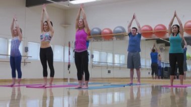 Stüdyoda yoga yapan bir grup insan.