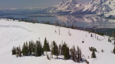 Grand Teton Ulusal Parkı, Rocky Dağları, Wyoming. Güzel kar manzaralı dağ tepeleri ve Jackson Gölü. Helikopterden Shotover gimbal ve RED 8K kamera ile çekildi..