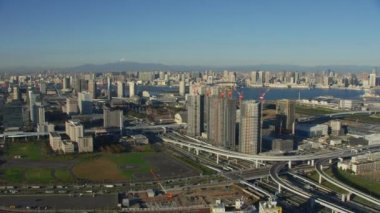 Tokyo, Japonya 2018 dolaylarında. Gökkuşağı Köprüsü 'ne ve şehre doğru inşaat vinçlerinin üzerinden uçuyor. Kırmızı kamerayla helikopterden çekilmiş..