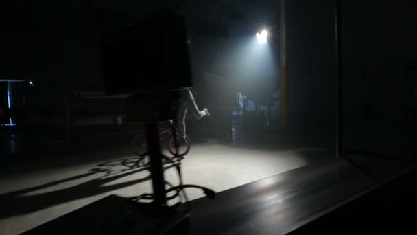 暗い倉庫でトリックをやっているBmxライダー — ストック動画