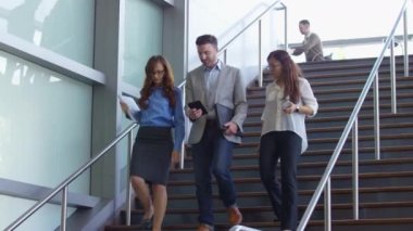 Bir grup iş adamı merdivenlerden aşağı iniyor.