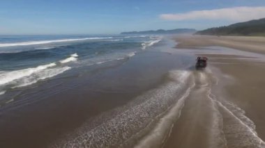 Sahilde giden 4x4 off road aracının hava görüntüsü.