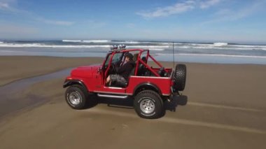 Sahilde giden 4x4 off road aracının hava görüntüsü.