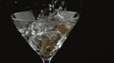 Yavaş çekimde zeytinler martiniye sıçrıyor.