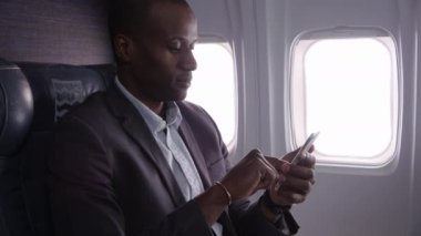 Uçak uçuşunda cep telefonu kullanan bir iş adamı.