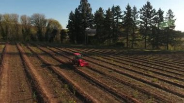 Tarlada sıra sıra ilerleyen traktörün hava görüntüsü