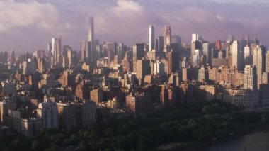 New York City 2017 dolaylarında, Manhattan binaları ve rıhtımlarıyla gündoğumunda Hudson Nehri 'nde uçuyor. Cineflex ve RED Epic-W Helyum ile çekilmiştir..