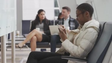 Havaalanında cep telefonu kullanan bir kadın.