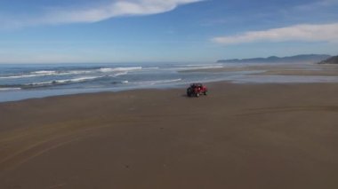 Sahilde giden 4x4 off road aracının hava görüntüsü.