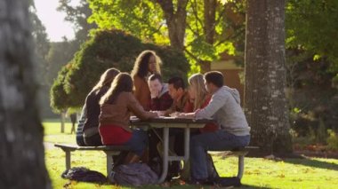 Kampüsteki bir grup üniversite öğrencisi açık havada buluşuyor.