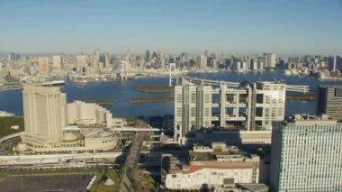 Tokyo, Japonya 2018 dolaylarında. Gökkuşağı Köprüsü ve Tokyo Kulesi ile Fuji TV binasının yanından uçuyor. Kırmızı kamerayla helikopterden çekilmiş..