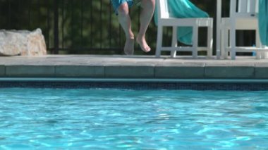 Süper yavaş çekimde havuza sıçrayan çocuğun yakın çekimi.