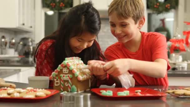 クリスマスのためのジンジャーブレッドハウスを飾る — ストック動画