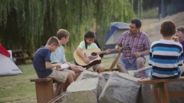 Yaz kampındaki çocuklar kamp ateşi etrafında.