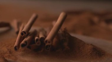 Tarçın çubukları pudralanmış tarçın içine düşüyor. Süper yavaş çekimde, Fantom Flex 4K 'de çekiliyor.