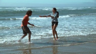 Plajdaki çift ağır çekimde oynuyor.