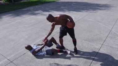 Bir sokak basketbolu; oyuncu saha dışında rakiplerine yardım ediyor