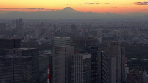 日本約2018年 遠くに富士山と夕日の前に東京都の建物 レッドカメラでヘリコプターから撃たれた — ストック動画