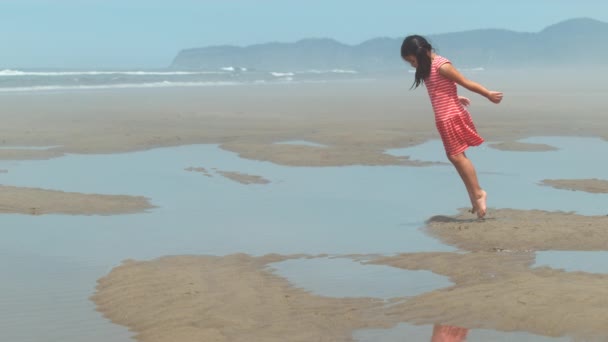 女孩在海滩跳进水坑 动作缓慢 — 图库视频影像