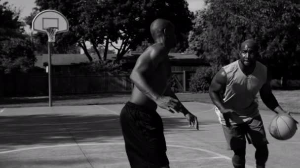 アフリカ系アメリカ人男性がストリートバスケットボールをする — ストック動画