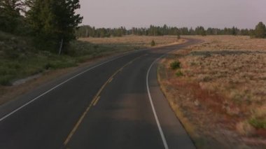 Grand Teton Ulusal Parkı 'nda yol boyunca araba sürüyorum.
