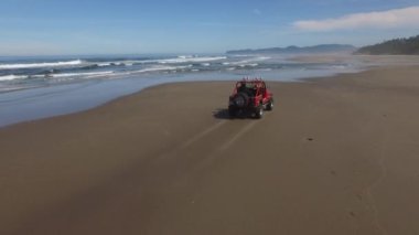 Sahilde giden 4x4 off road aracının hava görüntüsü.