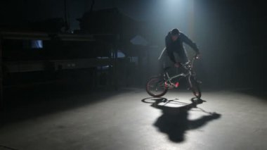 Bmx binici karanlık depoda hile yapıyor.