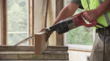 İnşaat işçisi testereyle kesme tahtası