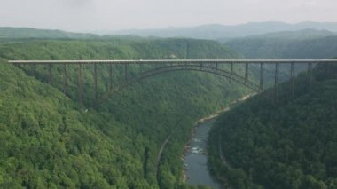 Batı Virginia, ABD 'deki dağ ormanlarındaki nehrin üzerindeki köprü manzarası.