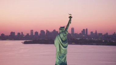 New York City, New York dolaylarında 2019. Güneş doğarken Özgürlük Anıtı 'nın havadan görünüşü. Helikopterden Cineflex gimbal ve RED 8K kamerayla çekildi..