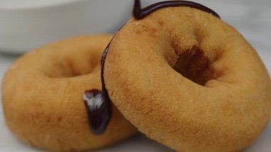 Çöreğin üzerine çikolata döküyorum. Kırmızı 8K kamerayla çekilmiş..