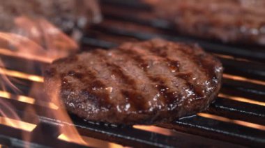 Izgarada pişen hamburgerlerin yakın çekimi, yavaş çekim..