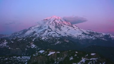 Mount Rainier, Washington 2019 dolaylarında. Gün batımında Rainier Dağı 'nın havadan görünüşü. Helikopterden Cineflex gimbal ve RED 8K kamerayla çekildi..