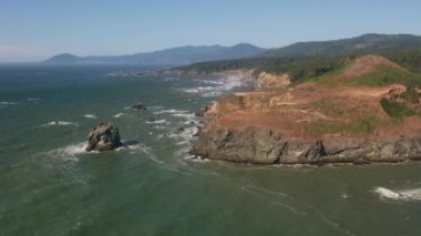 Güzel sahil ve deniz manzarasının üstünde doğa manzarası var. 