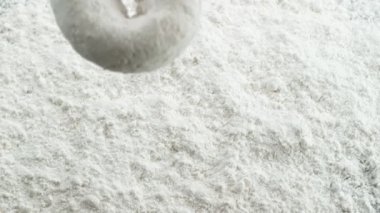 Yavaş çekimde pudra şekerinin içine düşen pudra çöreği. Phantom Flex 4K kamera ile çekildi..
