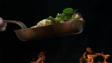 Erişteleri ve sebzeleri çok yavaş çekimde alevlerle karıştır. Phantom Flex 4K kamera ile çekildi.