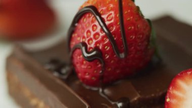 Taze çileklerin üzerine çikolata dökülüyor. Kırmızı 8K kamerayla çekilmiş..