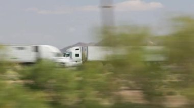 Kamyon, güzel doğa arasında yolda gidiyor.