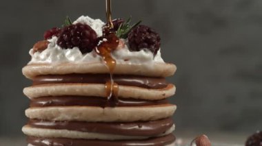 Krem şantili, fındıklı ve böğürtlenli kreplerin üzerine şurup dökülüyor. Phantom Flex 4K kamera ile çekildi..