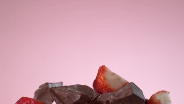 イチゴとチョコレートはゆっくりとした動きで茶色の背景を飛んでいます Phantom Flex 4Kカメラで撮影 — ストック動画