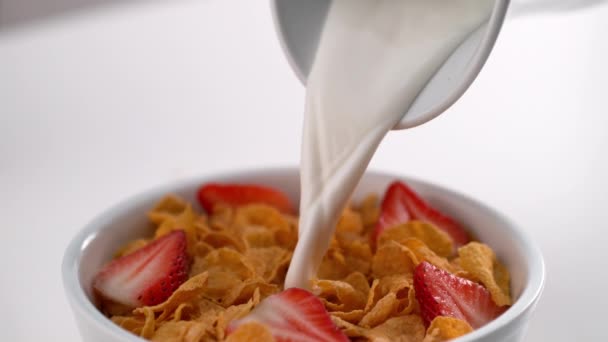 Melk Een Kom Smakelijke Cornflakes Gieten Met Gehalveerde Aardbeien — Stockvideo