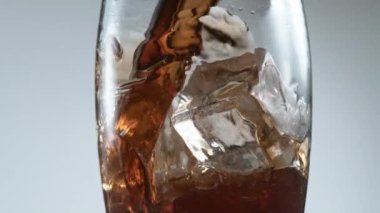Süper ağır çekimde buzun üzerine kola dökmek. Phantom Flex 4K yüksek hızlı kamera görüntüsü.