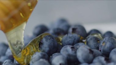 Taze yaban mersininin üzerine bal serpiştirilmiş. Kırmızı 8K kamerayla çekilmiş..