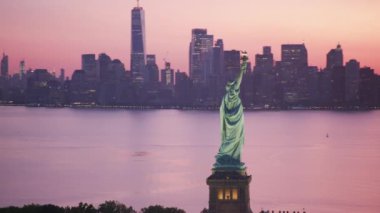 New York City, New York dolaylarında 2019. Güneş doğarken Özgürlük Anıtı 'nın havadan görünüşü. Helikopterden Cineflex gimbal ve RED 8K kamerayla çekildi..