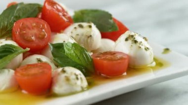 Caprese salatasına zeytinyağı serpiştiriyor. Phantom Flex 4K kamera ile çekildi..