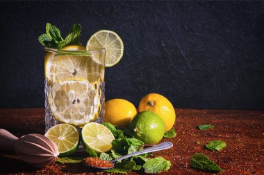 Limonlu mojito kokteyli ve gri taş arka planda cam bardakta nane şekeri.