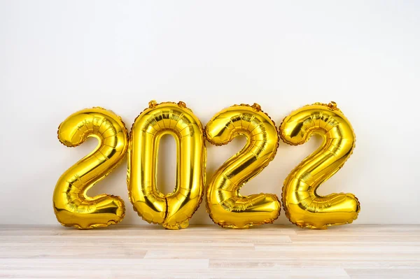 白い壁の背景に金ヘリウム気球の数字2022 新年のコンセプト 挨拶状 招待状 — ストック写真