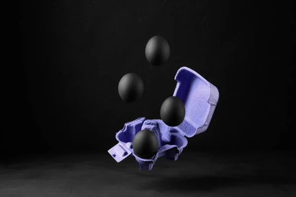 Flutuando Ovos Pintados Preto Sobre Recipiente Fundo Escuro Conceito Criativo — Fotografia de Stock