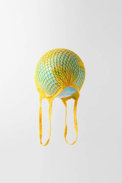 Globo Mundial Saco Crochê Amarelo Flutuando Fundo Cinza Claro Vida — Fotografia de Stock